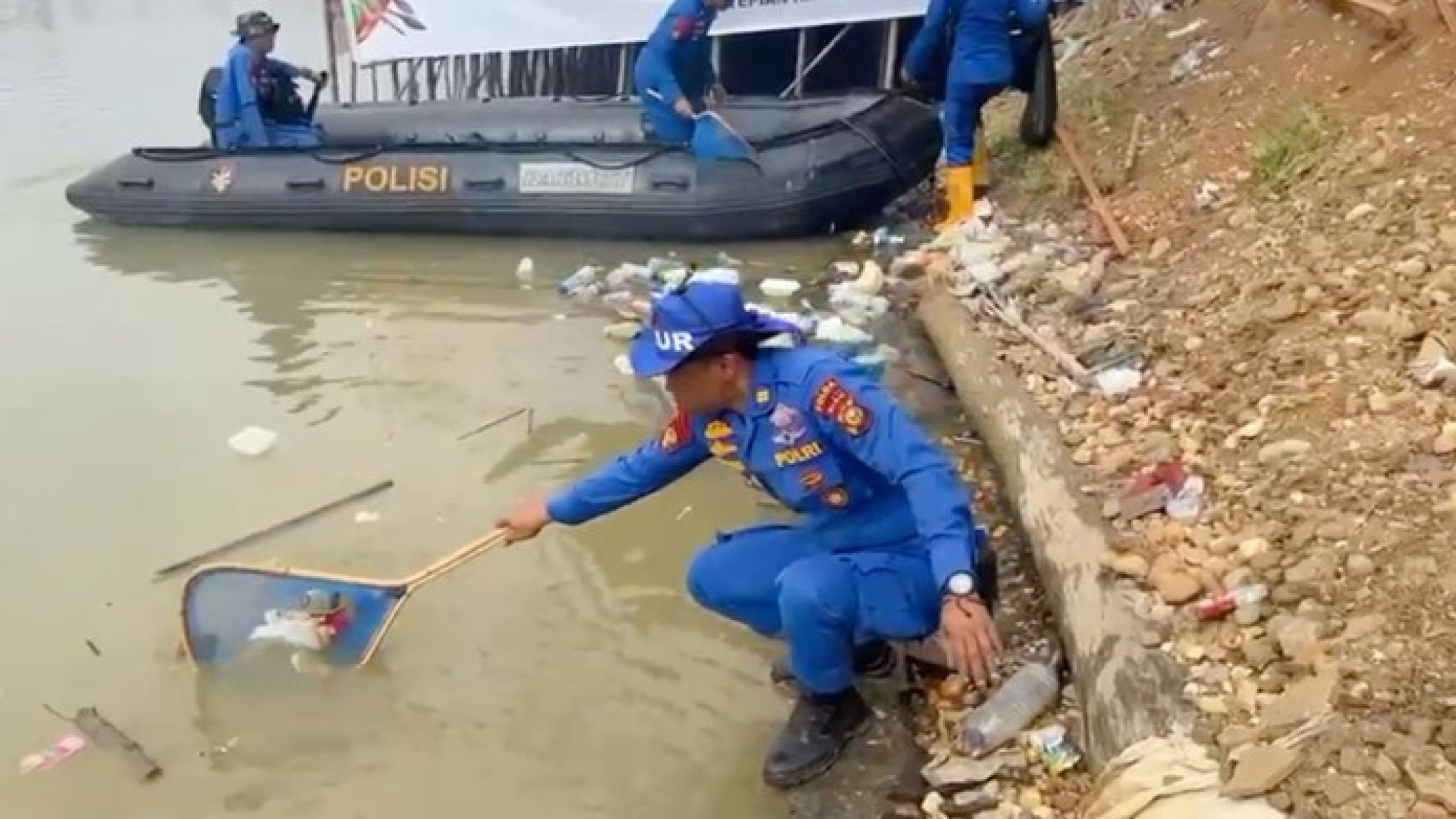 Personel Polda Riau Bersih-bersih Sampah di Tepian Narosa Arena Pacu Jalur